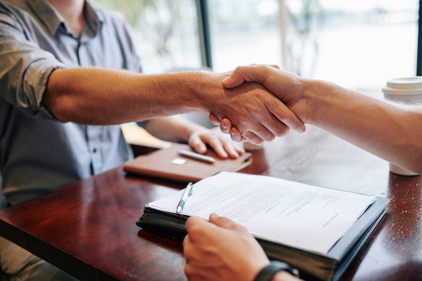 Close-up image of business people shaking hands after signing contract - Fotó, kép