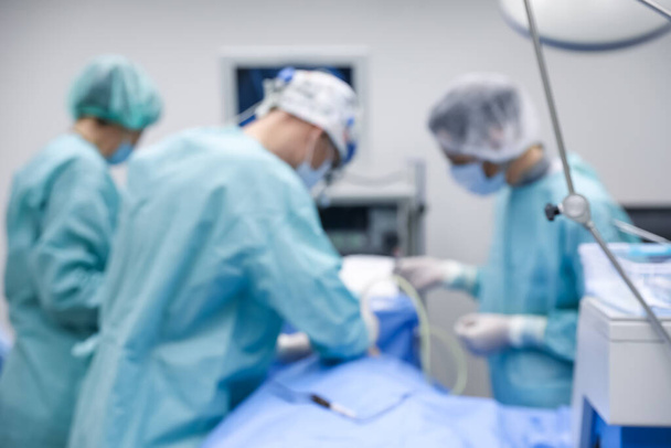 Blurred view of doctors operating patient in surgery room - Photo, Image