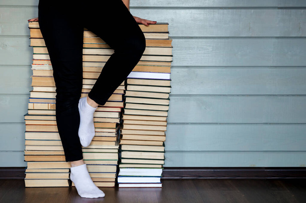 Mulher sentada na montanha de arquivos de livros. Pernas em meias brancas
 - Foto, Imagem