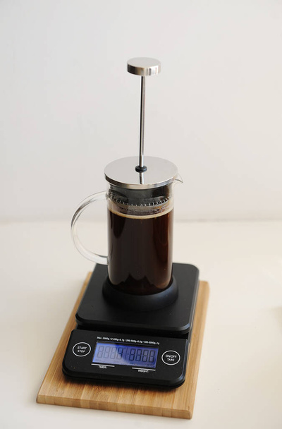 Brewing coffee in french press. Plunger not lowered. On black electronic timer scales. Specialty concept - Photo, Image
