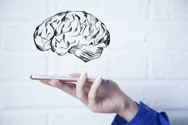 businesswoman holding smart phone with brain in screen - Photo, Image