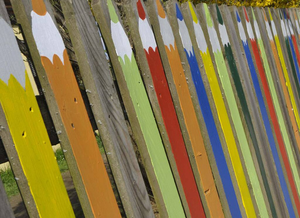 uma cerca de madeira com pintado sobre lápis de cor na esgrima
 - Foto, Imagem
