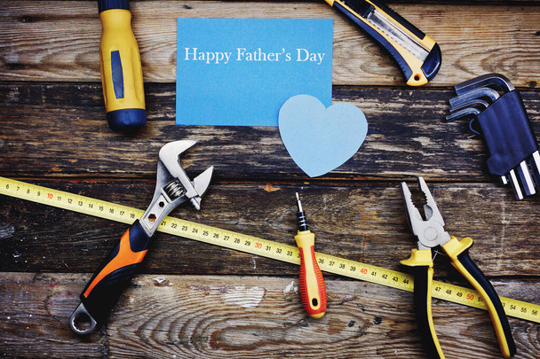 Happy father`s day background concept. Top view of construction handy tools on the wooden background. - Fotó, kép