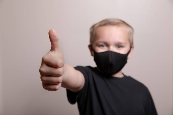 Jeune garçon montrant une certaine positivité tout en portant son masque
 - Photo, image