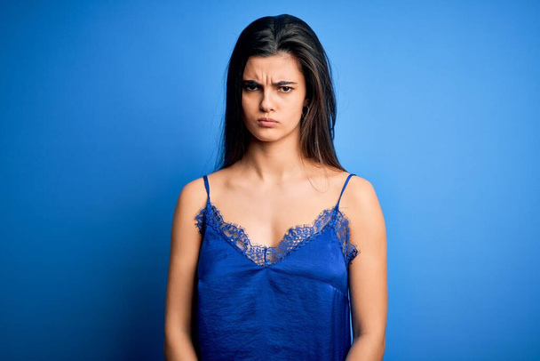 Young beautiful brunette woman wearing elegant and comfortable blue lingerie underwear skeptic and nervous, frowning upset because of problem. Negative person. - Foto, afbeelding