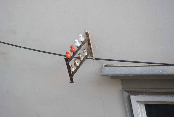 a ceramic insulator mounted on the wall of a building - Photo, Image