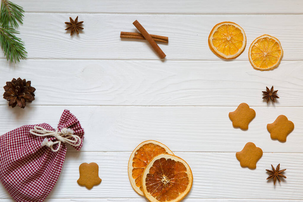Fond de fête de Noël, orange séchée sicilienne rouge, pommes de pin, oranges séchées, étoiles d'anis et biscuits au gingembre sur fond de table rustique en bois blanc, vue sur le dessus. Espace de copie
.  - Photo, image