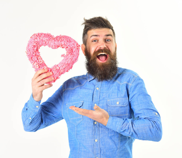 Man with happy face holds pink heart, symbol of love. - Foto, imagen