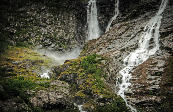 Sziklás táj a drámai norvég vízesés körül rövid bokrok és minimális növényzet. - Fotó, kép