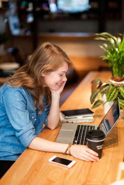 Side view happy woman with coffee watching laptop - Фото, зображення