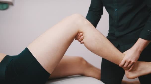 Physiotherapie. Techniker inspiziert die Flexibilität des Knies. Gesundheitsfürsorge und Erholung  - Filmmaterial, Video