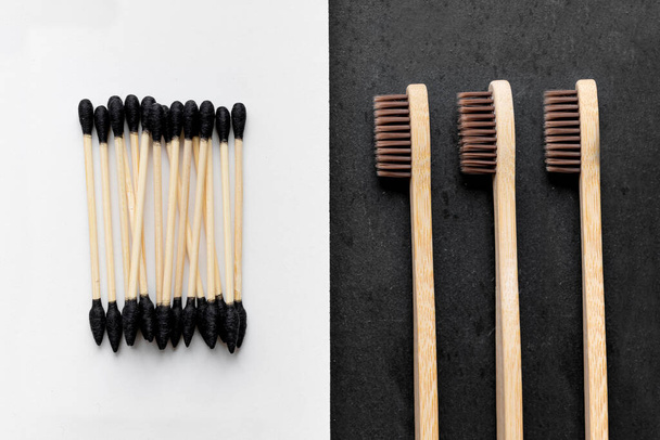 Orejas y cepillos de dientes biodegradables sobre fondo blanco y negro
 - Foto, Imagen