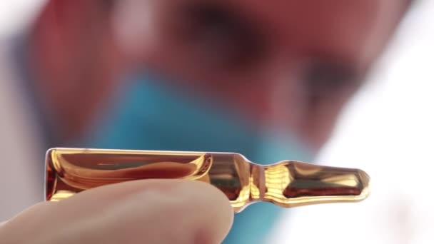 Medical researcher watching brown vaccine vial in horizontal way - Footage, Video