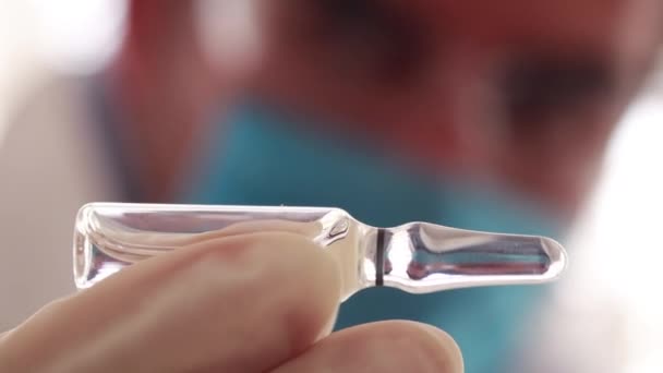 Epidemioloog die de injectieflacon met wit vaccin horizontaal observeert - Video
