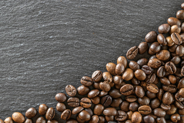 Essen, trinken Koffein Hintergrund. Dunkle Kaffeebohnen für eine Tasse schwarzen Espresso im Café. Morgens Energiekonzept und Heiterkeit oder abends Erfrischung. Kopierraum, Ansicht von oben. - Foto, Bild