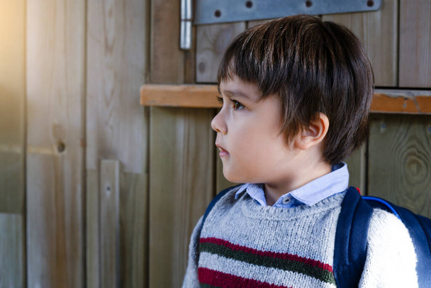 Muotokuva puolella näkymä söpö pieni poika etsii ulos utelias kasvot, koulu Lapsi carring reppu ged valmis luokkaretkelle
.   - Valokuva, kuva