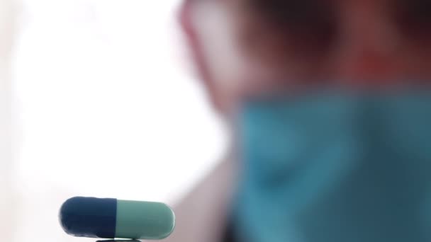 Ιατρικός ερευνητής παρακολουθεί προσεκτικά μια μπλε κάψουλα - Πλάνα, βίντεο