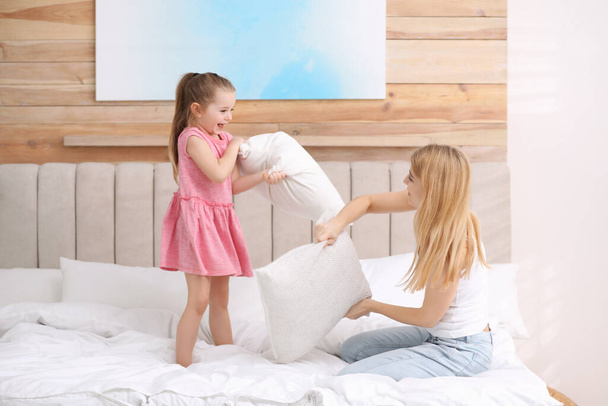 Mother playing with her child in bedroom at home - Φωτογραφία, εικόνα