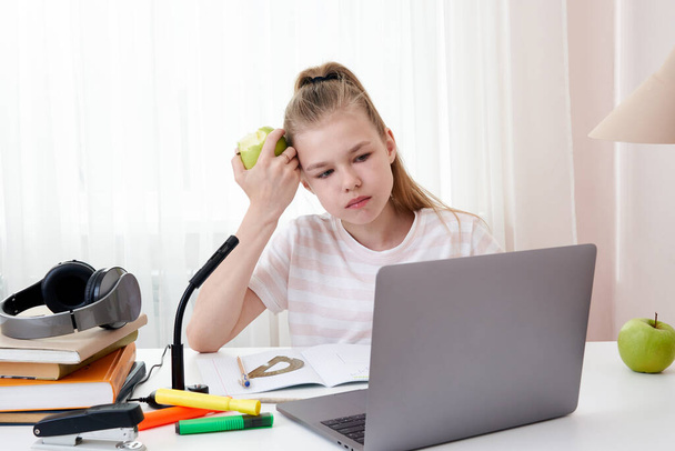 Teini-ikäinen tyttö opiskelee videoneuvottelun kautta, verkko-oppimista opettajan ja luokkatovereiden kanssa tietokoneella kotona. Kotikoulu ja etäopetus, verkko-opetuksen käsite
 - Valokuva, kuva