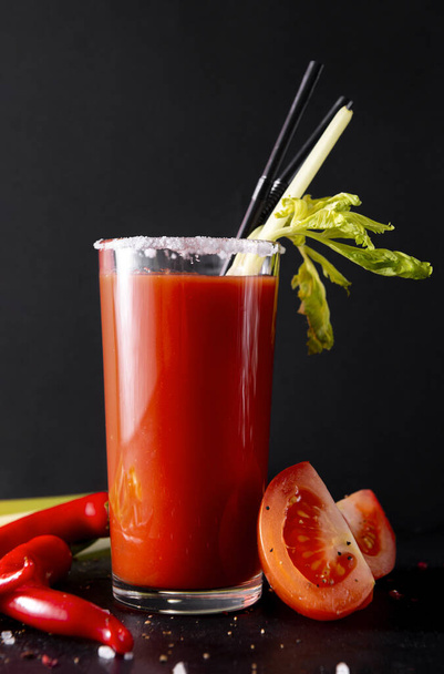 1 glass of tomato juice with fresh tomatoes, celery, cocktail tubes, red and black background,  cocktail bloody Mary,  - Photo, image
