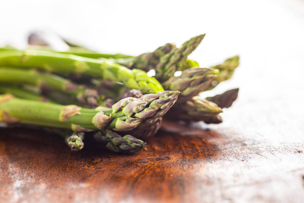 Fresh green asparagus. Healthy seasonal vegetable on wooden table. - 写真・画像
