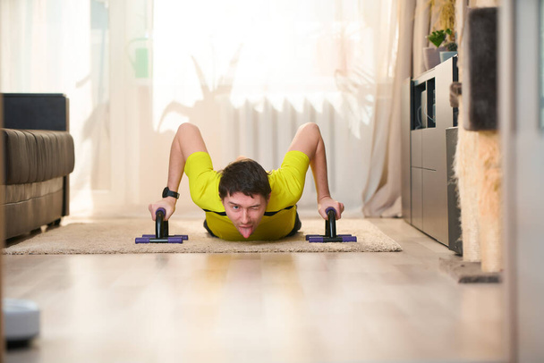 Man doing push ups exercise using Push-up Bars at home - Fotoğraf, Görsel
