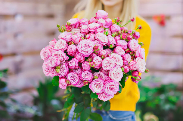 a bouquet of pink roses in the hands of a seller in a flower shop - Foto, Imagem