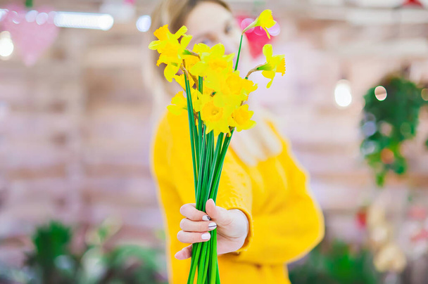 a bouquet of yellow flowers in the hands of a seller in a flower shop - Fotoğraf, Görsel