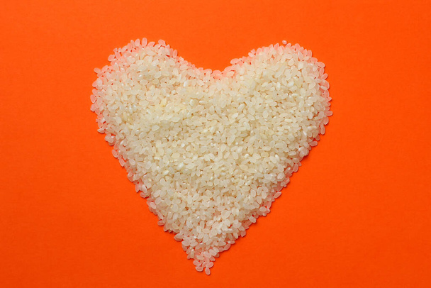 Λευκό ρύζι σε σχήμα καρδιάς, αφηρημένο όμορφο φόντο - Φωτογραφία, εικόνα