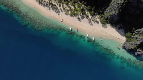 Letecký pohled na tyrkysovou tropickou lagunu s krasovými vápencovými útesy na ostrově Black (Malajon), Coron, Palawan, Filipíny, kotvení lodí - Záběry, video