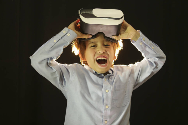 Jongen geniet van zijn 3D virtual reality bril thuis of op school - Foto, afbeelding