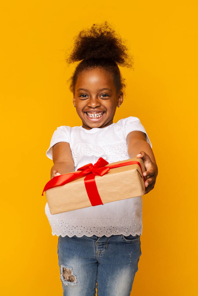 słodkie nieśmiały mało afrykański dziewczyna dając prezent pudełko w aparacie - Zdjęcie, obraz