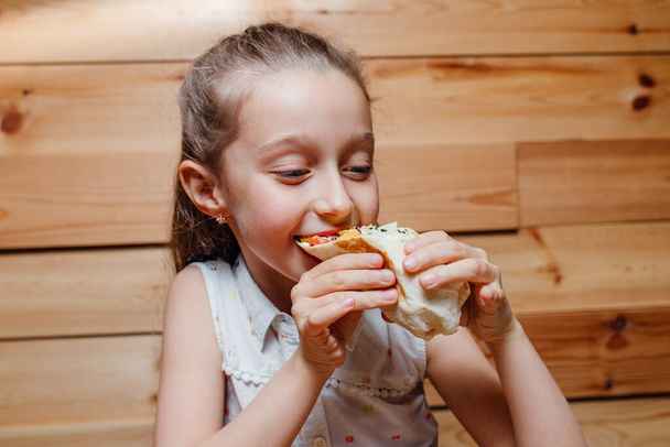 happy little girl eat vegetarian Wrap iceberg - Фото, изображение