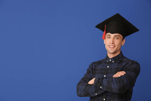 Молодий чоловік у випускному капелюсі на кольоровому фоні
 - Фото, зображення
