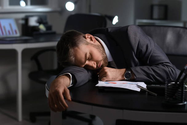 Sleeping businessman in office late at night - Fotoğraf, Görsel