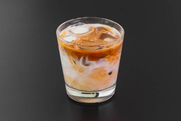 glass of iced coffee with ice cubes on wooden table - Fotografie, Obrázek