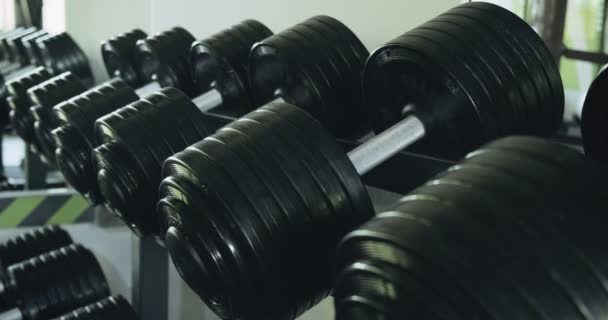 Dumbbells row in modern sport club gym. Close up of sport equipment - Footage, Video