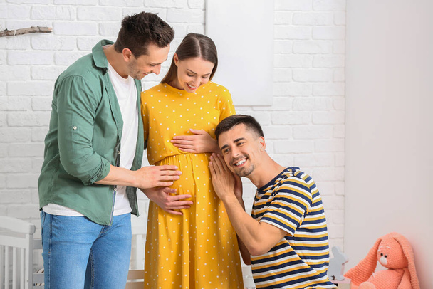 Pareja gay con mujer embarazada en casa
 - Foto, imagen