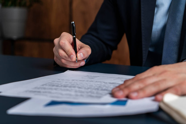 Egy férfi bróker aláírta a jelzálogszerződést az ingatlanügynökségen. A felelősségvállalás jogi hatáskörének gyakorlása. - Fotó, kép