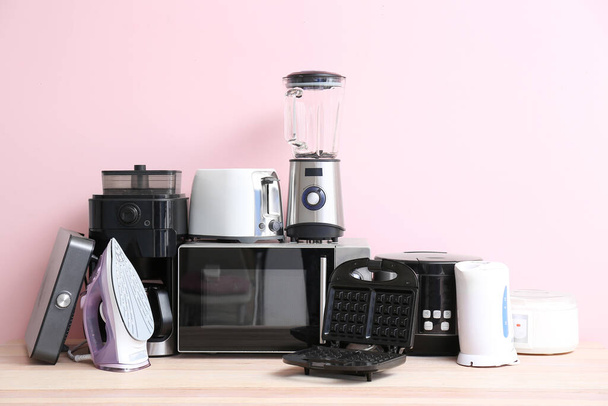 Verschillende huishoudelijke apparaten op tafel - Foto, afbeelding