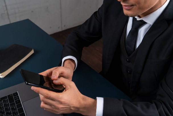 Бизнесмен использует смартфон за рабочим столом
 - Фото, изображение