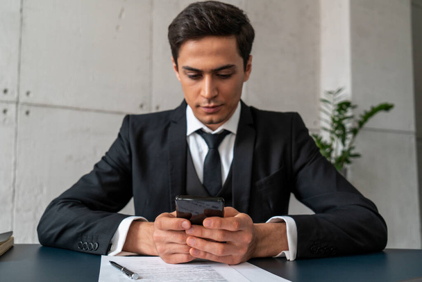 Serious young businessman texting in office - Foto, Imagem