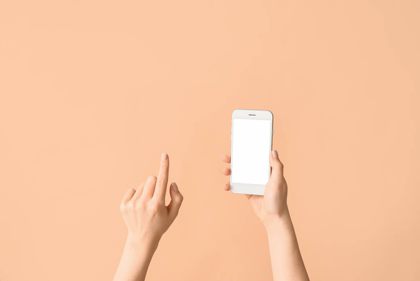Female hands with mobile phone on color background - Photo, Image
