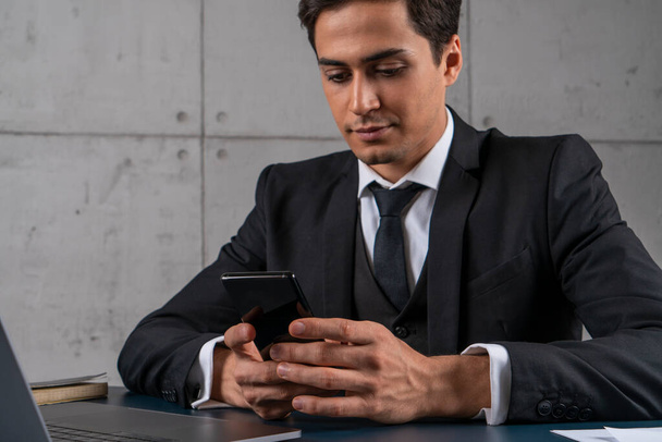 Vista lateral de hombre de negocios serio con teléfono inteligente
 - Foto, imagen