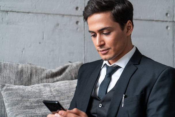 Young businessman using smartphone in loft office - Foto, Bild