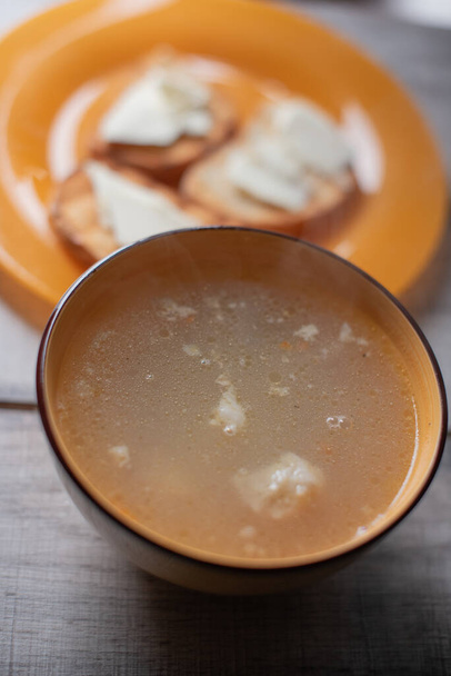Курячий суп з макаронами на столі. Паста суп і хліб і масло
 - Фото, зображення