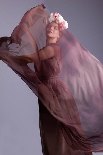 Привлекательная женщина в розовом шифонском платье и танцующая с шифонной вуалью
. - Фото, изображение