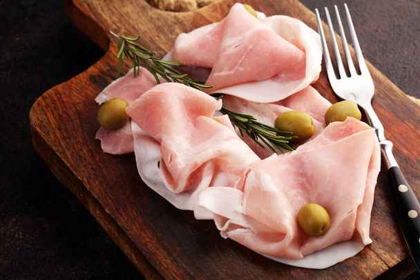 Sliced ham on wooden background. Fresh prosciutto. Pork ham sliced. meat cutting - Photo, Image