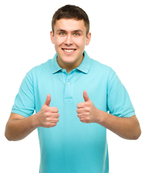 χαρούμενος νεαρός άνδρας που δείχνει τον αντίχειρα επάνω σημάδι - Φωτογραφία, εικόνα