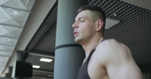 Man running on treadmill in gym. Men doing difficult cardio workout with air runner - Materiał filmowy, wideo